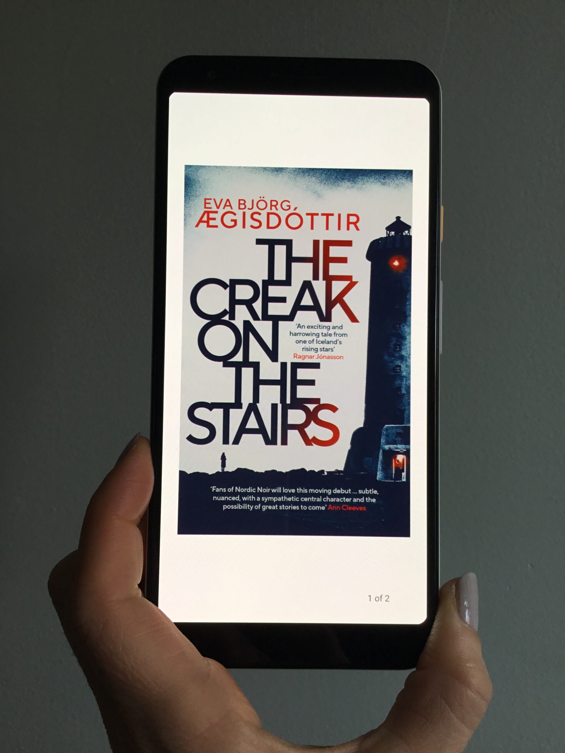 holding picture of book cover the creak on the stairs