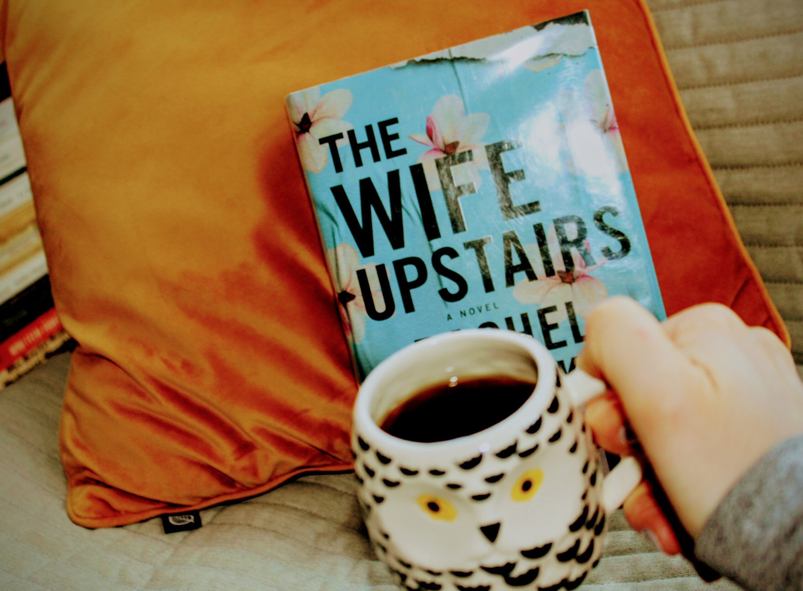 the wife upstairs against mustard pillow and owl coffee mug